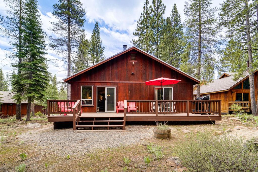 a large wooden cabin with a porch and a red umbrella at Home with Deck and Access to Tahoe Donner Amenities! in Truckee