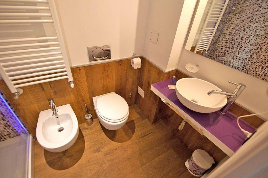 een badkamer met een wit toilet en een wastafel bij Barbacan Boutique Hotel in Trieste