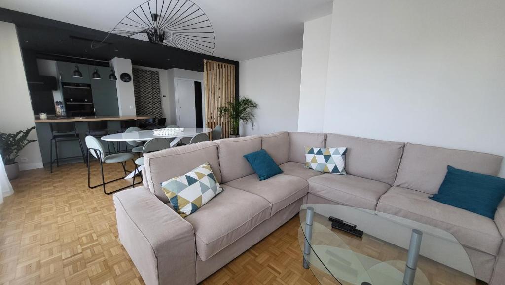 un salon avec un canapé et une table dans l'établissement Appartement spacieux et moderne, à Tours