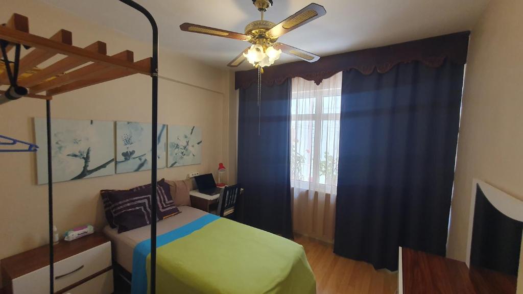 a bedroom with a bed and a ceiling fan at Feeling at home in İstanbul Center 5 Minutes walk to The Ataköy Metro Station & Metrobus in Istanbul