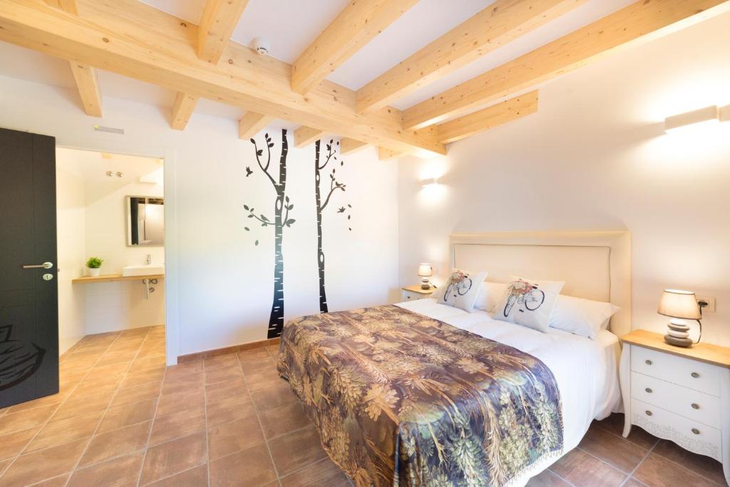 a bedroom with a bed with a tree mural on the wall at Landras de Compostela in Santiago de Compostela
