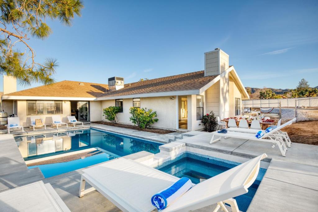 - une piscine avec des chaises et une maison dans l'établissement Mojave Moon by AvantStay Modern Bright JT Home in Great Location w Pool Hot Tub, à Yucca Valley