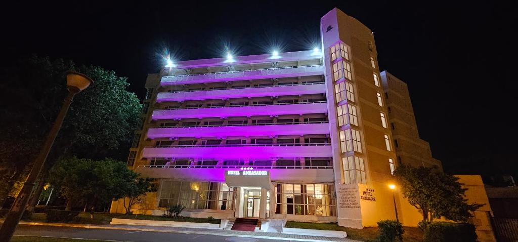 Un bâtiment avec des lumières violettes au-dessus dans l'établissement Hotel Ambasador Mamaia, à Mamaia