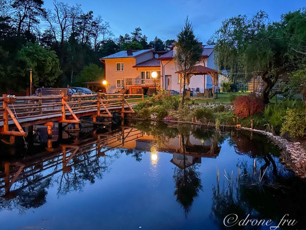 uma casa numa ponte sobre um rio à noite em Gospodarstwo Agroturystyczne Pod Lasem Maria Płazio em Narol