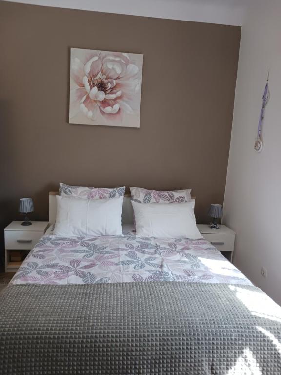1 dormitorio con 1 cama con una pintura floral en la pared en Studio Luna en Opatija