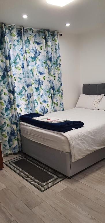 a bed in a bedroom with curtains and a bedvisor at Min Su Rooms in Stanwell
