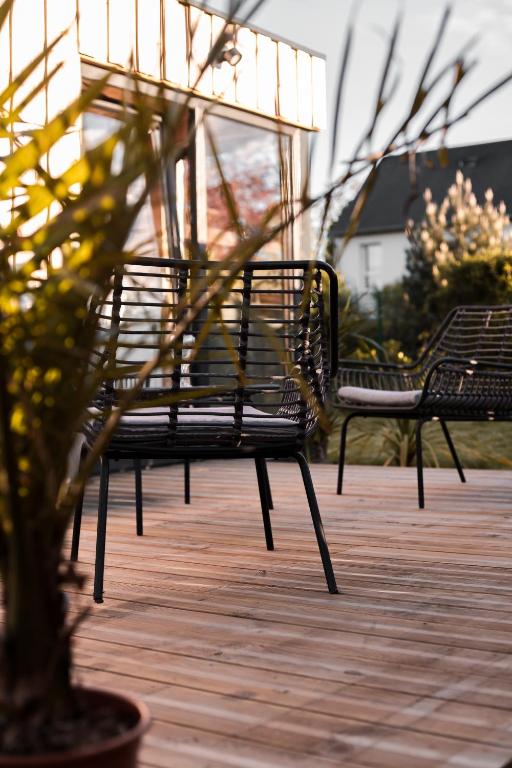 deux bancs assis sur une terrasse avec un arbre dans l'établissement Le coquillage, la clef des paons, à Luc-sur-Mer