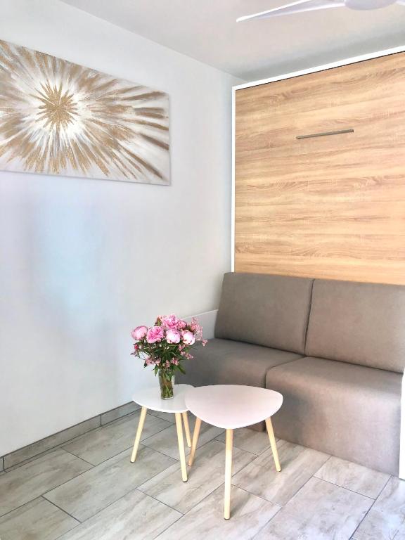 - un salon avec un canapé, une table et des fleurs dans l'établissement Studio Cosy + parking privé, à Cavalaire-sur-Mer