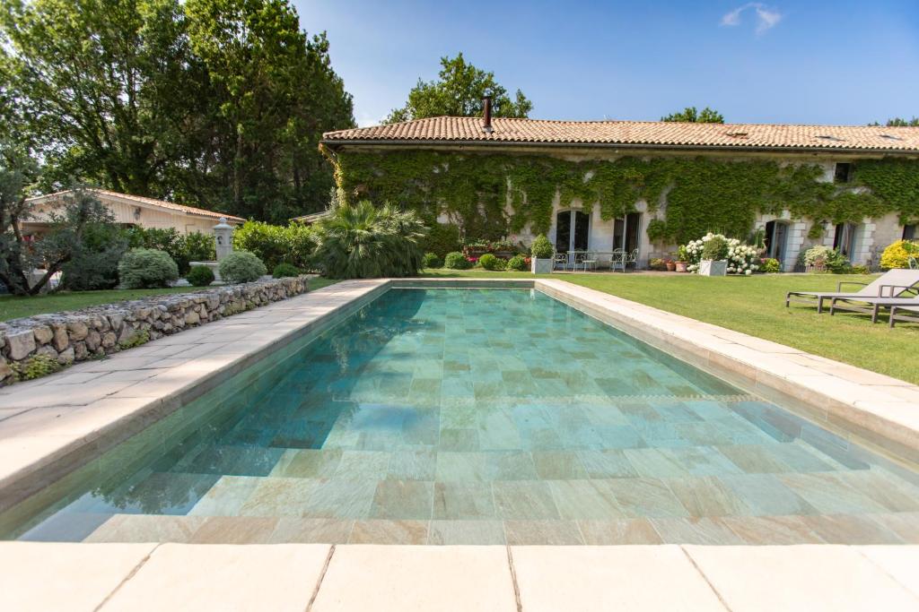 uma piscina no quintal de uma casa em Chambres d'hôtes Domaine de Ginouilhac em Le Taillan-Médoc
