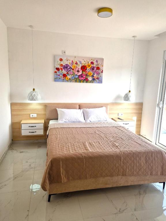 a bedroom with a bed and a painting on the wall at IVANA Apartments in Ulcinj