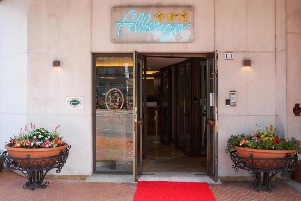 una entrada a un hotel con dos macetas de flores y una puerta en Hotel alla giustizia, en Mestre