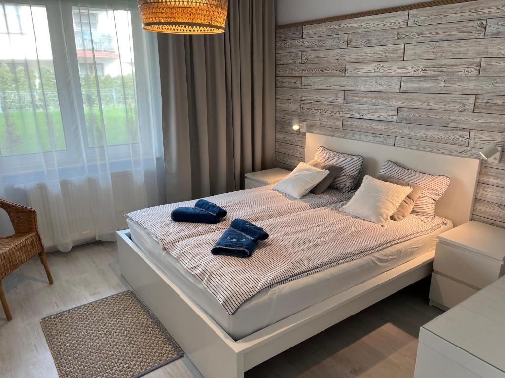 a bedroom with a bed with two blue towels on it at Darba 2 in Darłowo
