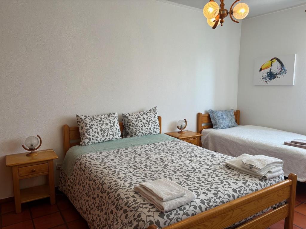um quarto com 2 camas e toalhas em Rosário - two bedroom apart- Buarcos - Figueira da Foz na Figueira da Foz