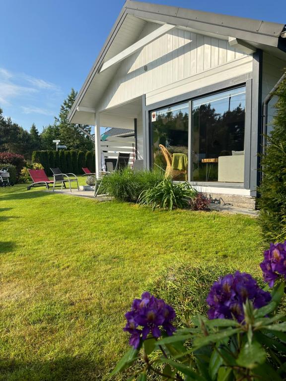 een huis met paarse bloemen in de tuin bij Balfala domki nad morzem in Ostrowo
