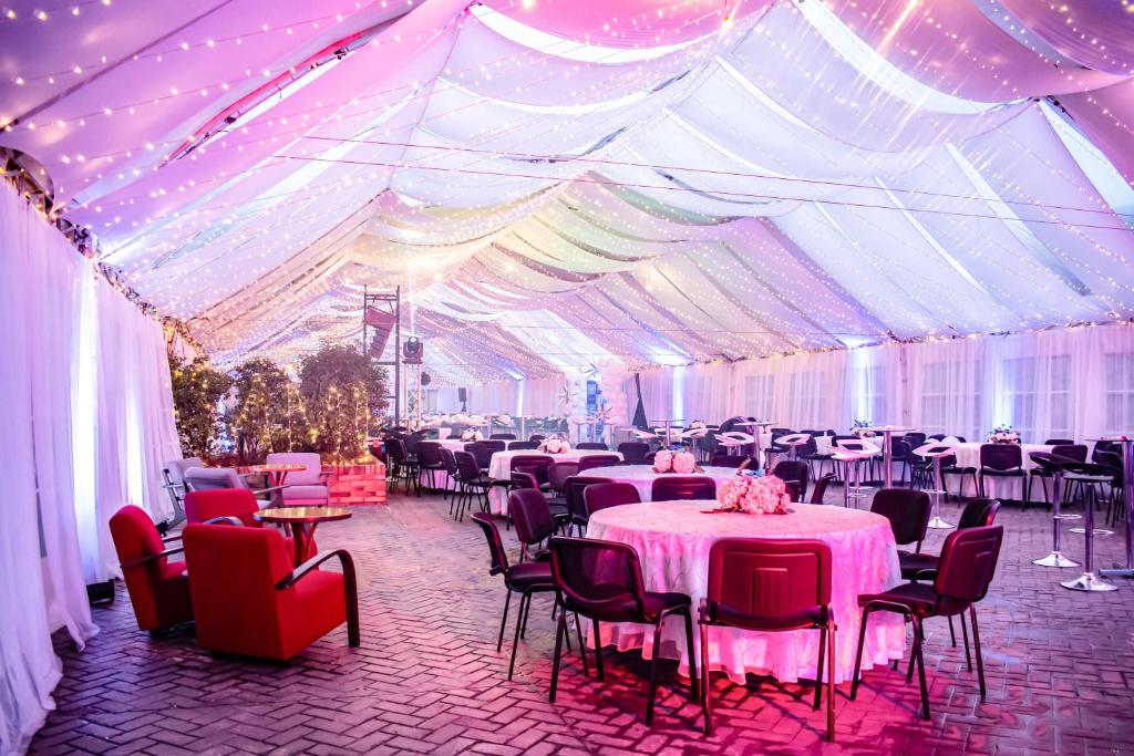 a large marquee with tables and chairs and lights at Hotel Habitel Select in Bogotá