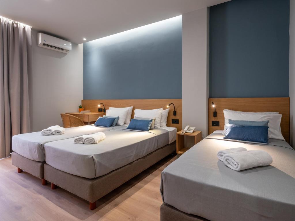 una camera con due letti e asciugamani di Athinaiko Hotel a Heraklion