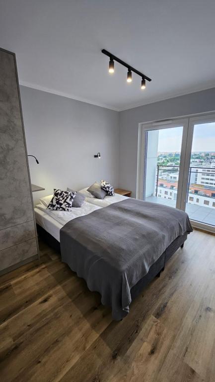 una camera con un grande letto e una grande finestra di Apartament Bułgarska 59 - sypialnia i salon - 40m2 - self check in 24h a Poznań