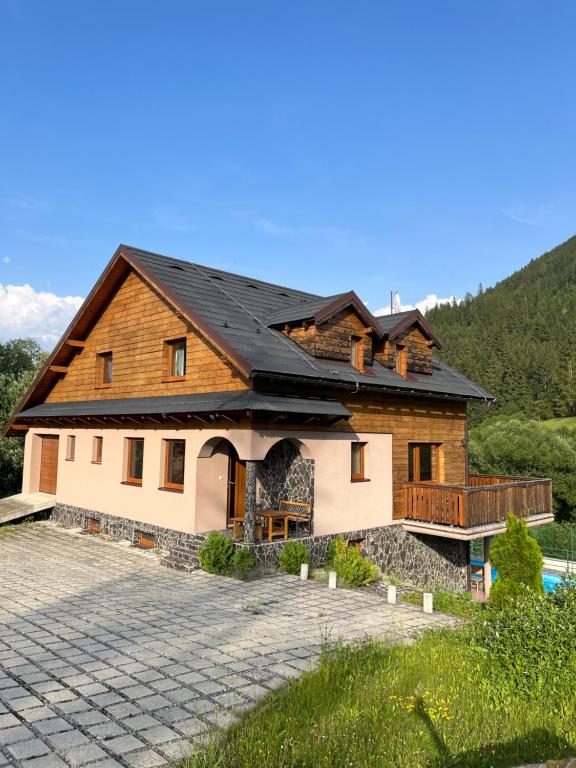 a house with a black roof and a patio at Chata Porubka in Liptovský Mikuláš