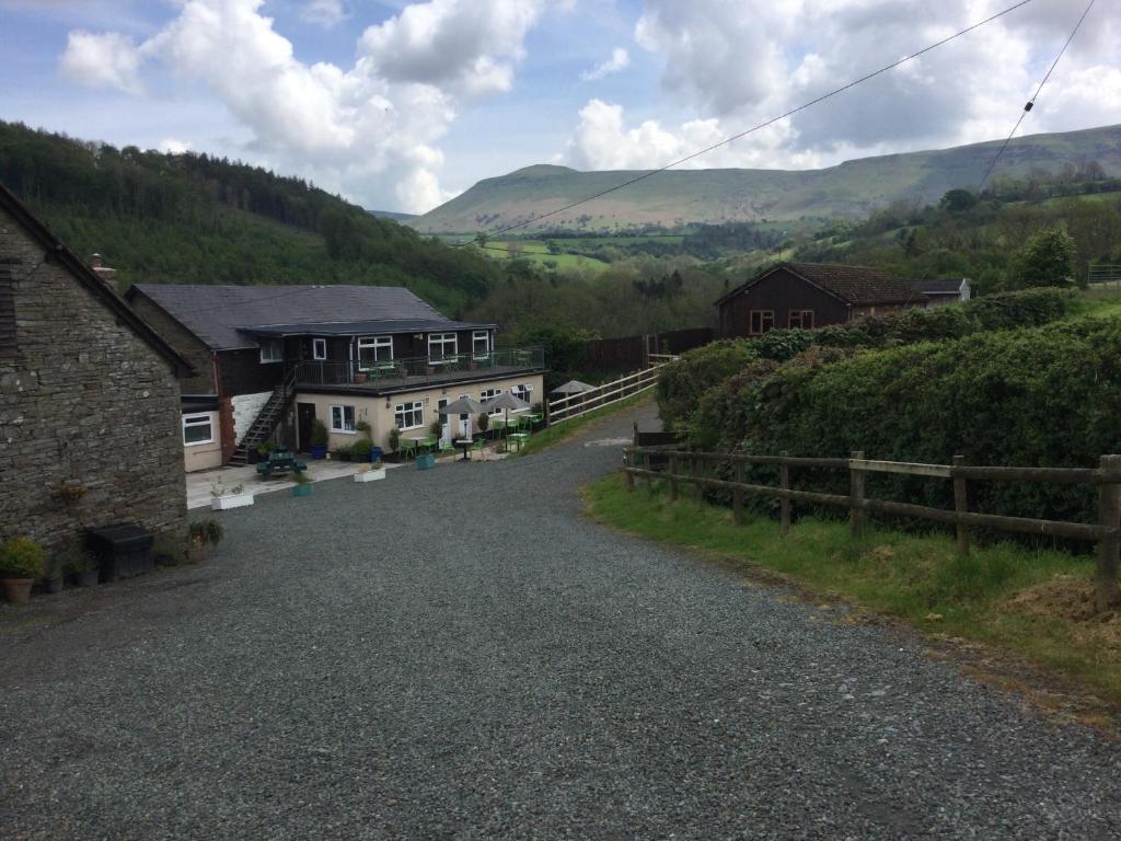 an empty road in a village with houses and hills at The Living Energy Holidays in Velindre