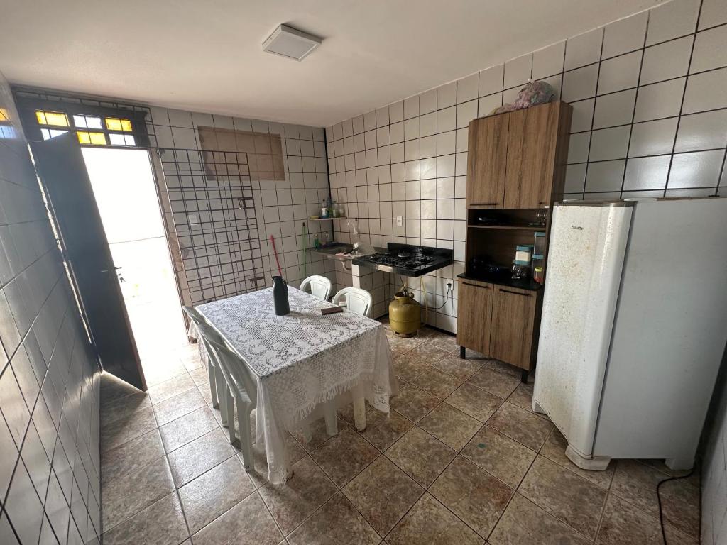 a kitchen with a table and a refrigerator at Casa de praia in São-José-do-Ribamar