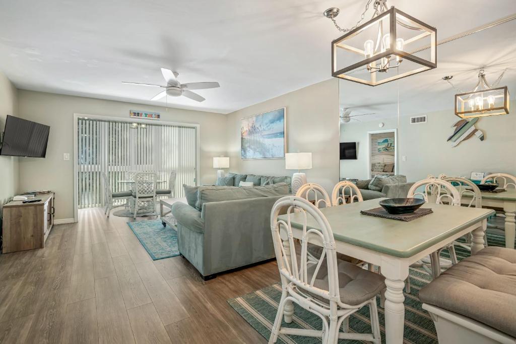 a living room with a couch and a table at Updated Condo with Pool, Walk to Crescent Beach & Restaurants! in Sarasota