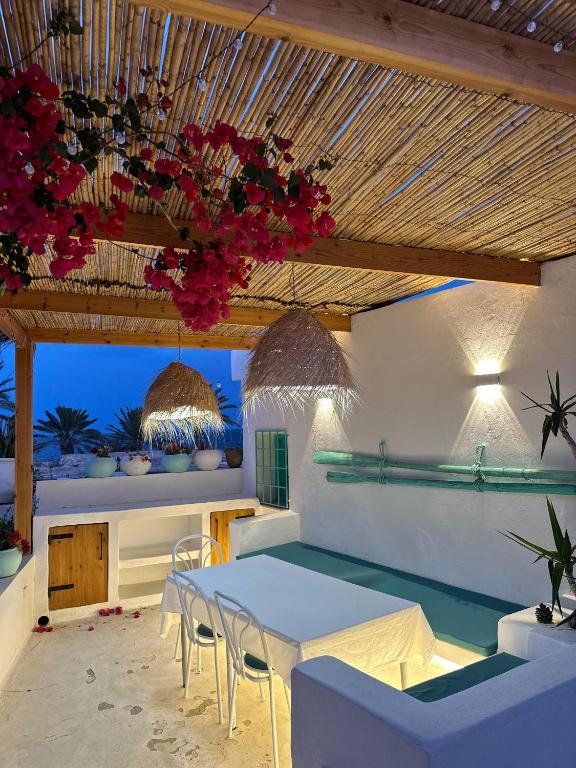 a dining room with a white table and chairs at Dar El Mahdia by Daldoul in Mahdia