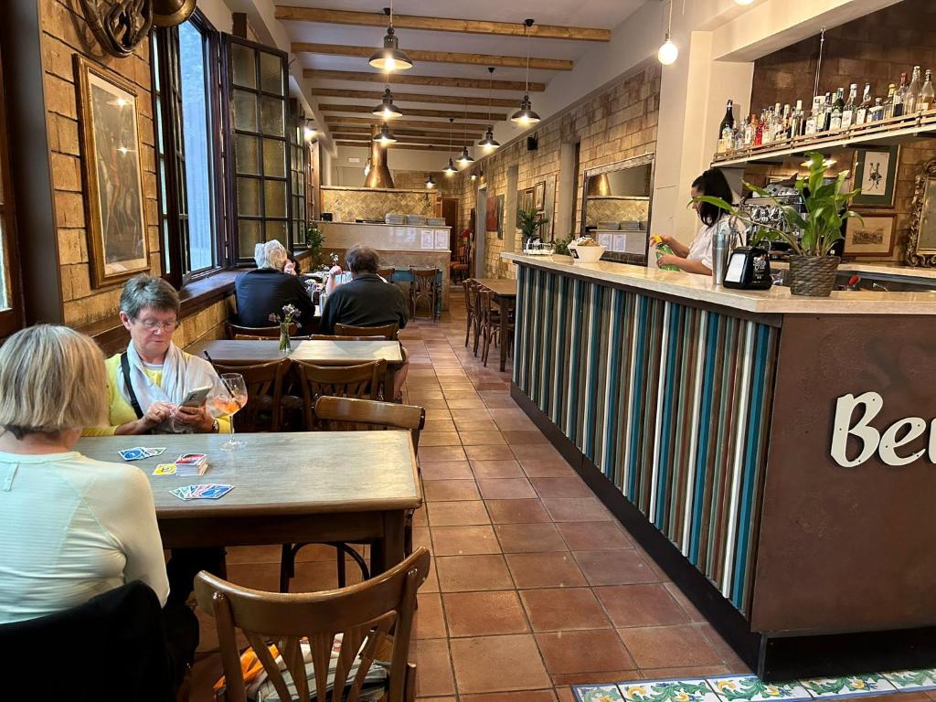 een groep mensen die aan tafel zitten in een restaurant bij Hotel Ristorante Benigni in Campagnano di Roma
