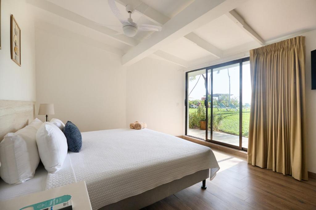 Postel nebo postele na pokoji v ubytování Perla de la Playa Beachfront Hotel
