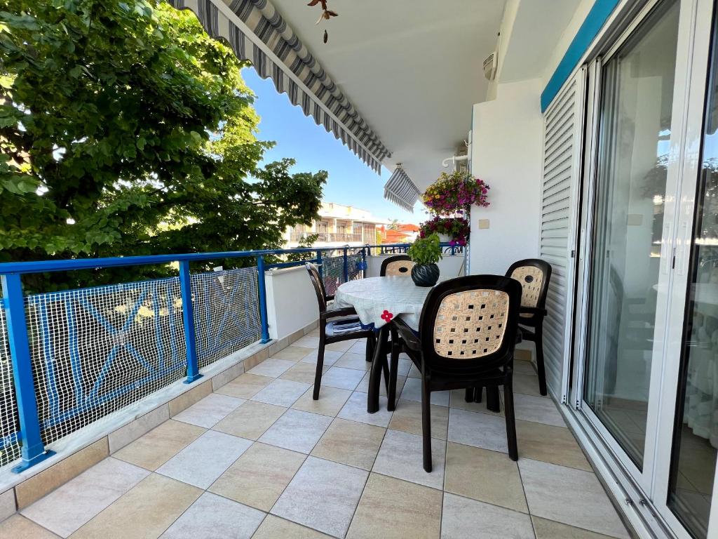 un patio con tavolo e sedie sul balcone. di Holiday House Kallithea a Kallithea