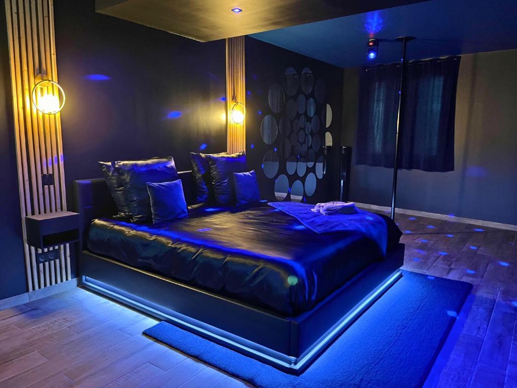- une chambre avec un grand lit et un éclairage bleu dans l'établissement Suite Casanova avec SPA & Escape Love Game - Doux Bleu Jeux, à Niort