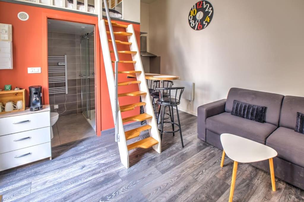 un salon avec un canapé et un escalier dans l'établissement Évasion Périgourdine, à Périgueux