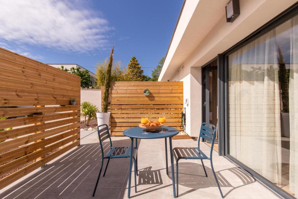 einen Tisch und Stühle auf einer Terrasse mit einem Zaun in der Unterkunft COCON NOELY 1 in Toulouse