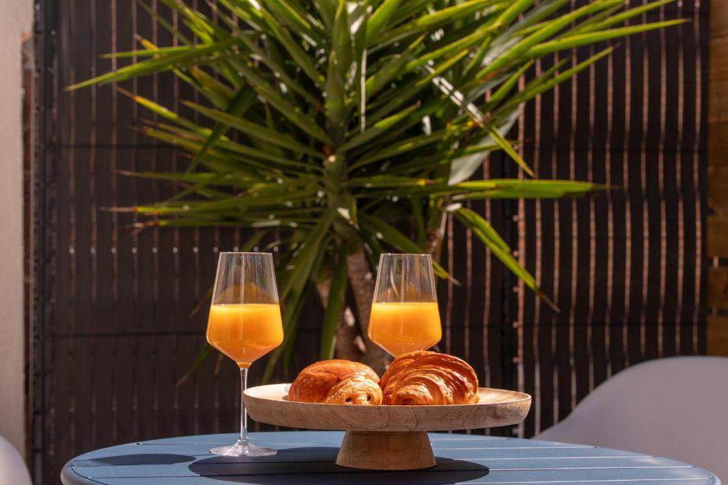 einen Tisch mit zwei Gläsern Orangensaft und Croissants in der Unterkunft COCON NOELY 1 in Toulouse
