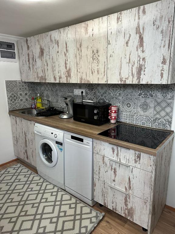 a kitchen with a sink and a washing machine at Guszti Apartman in Pécs