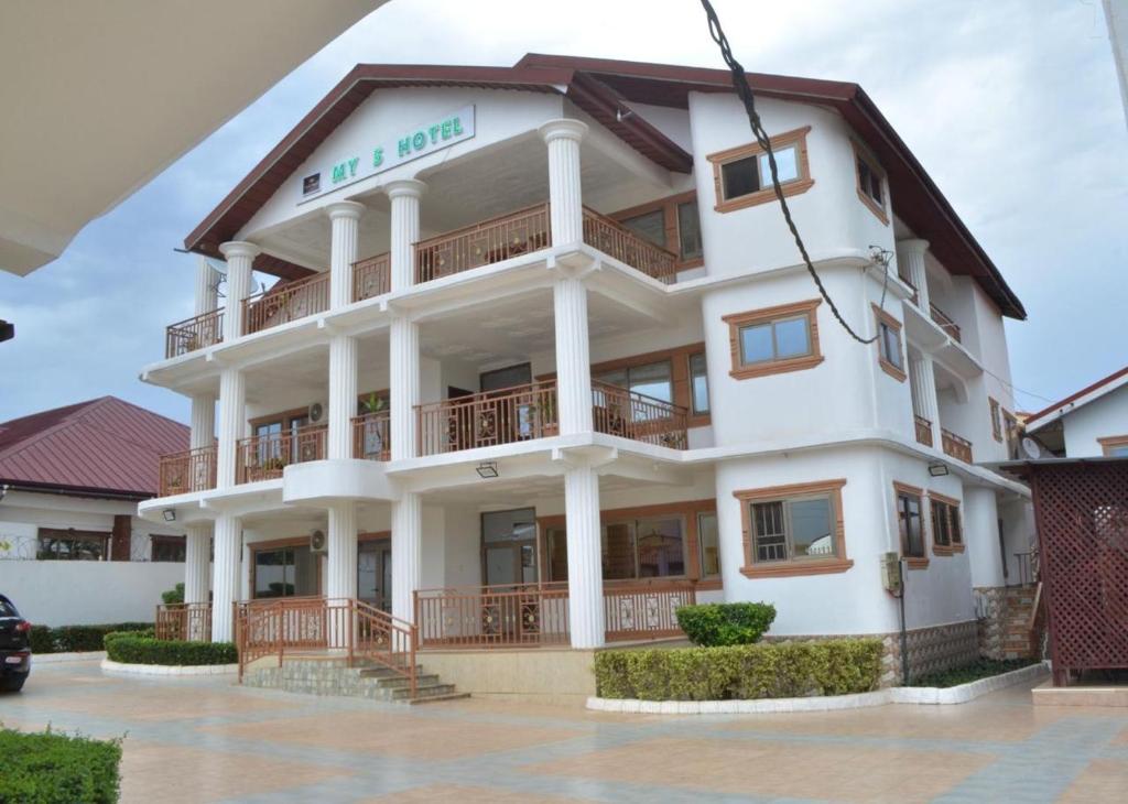 een groot wit gebouw met een balkon bij My5 Hotel in Kumasi