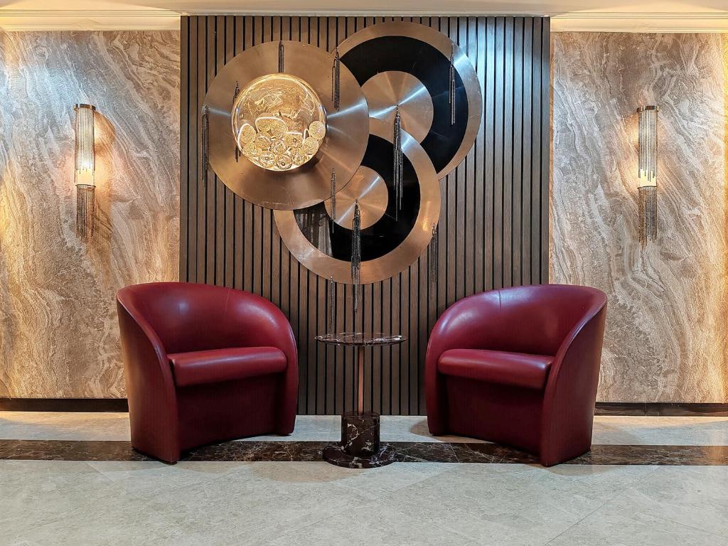 un vestíbulo con 2 sillas y una lámpara de araña en ELAN RIMAL SADAF Suites en Dubái