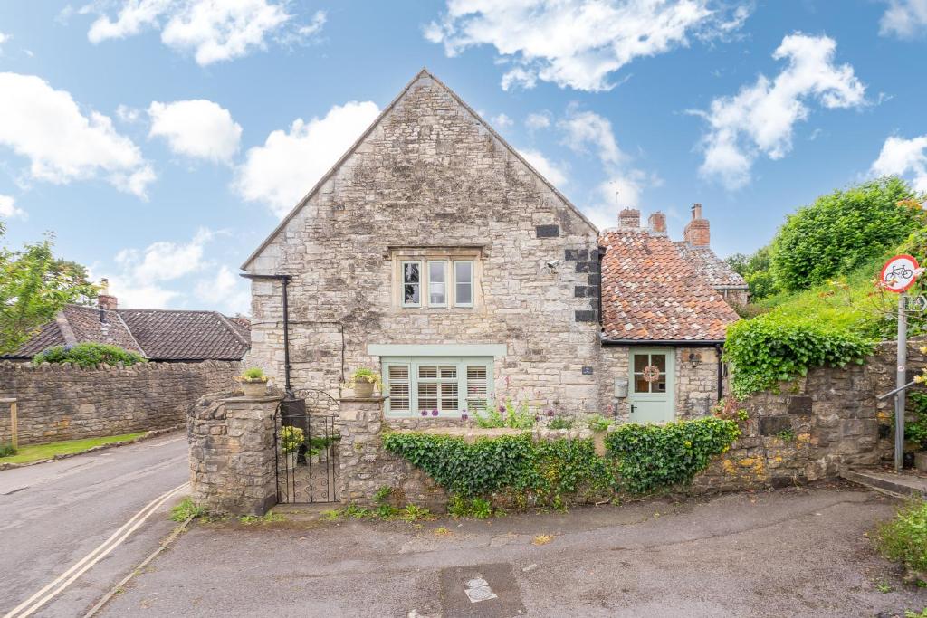 an old stone house on the side of a street at Cosy cottage on outskirts of Bath in Saltford