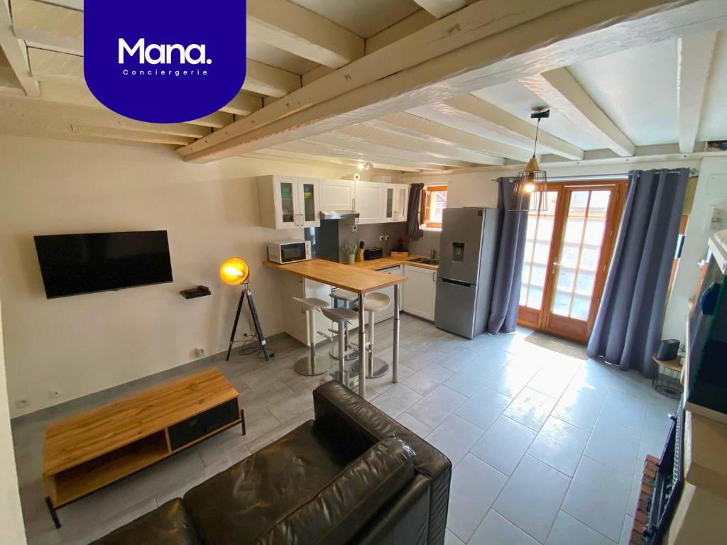 un salon avec un canapé et une cuisine dans l'établissement L'Escale - 2 km de la mer - Basilique Notre-Dame-de-la-Délivrande, à Douvres-la-Délivrande