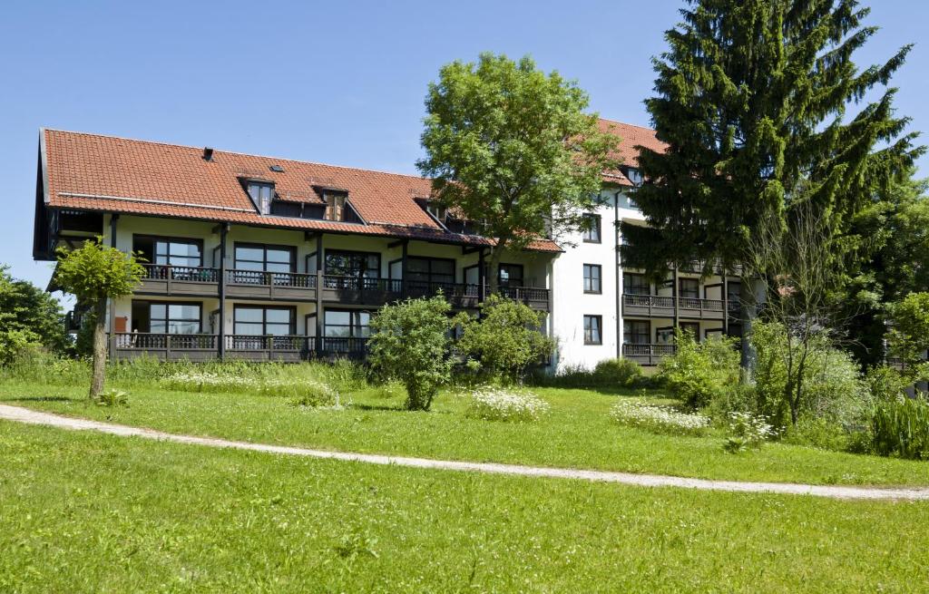 ein großes Gebäude mit einem Grasfeld davor in der Unterkunft Bad Füssing Appartementhof Aichmühle in Bad Füssing