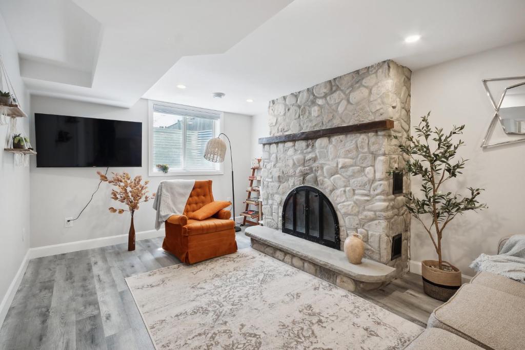 a living room with a stone fireplace and a chair at Haven Suite in London, On 2Br, 1Bath with free washer and dryer in London