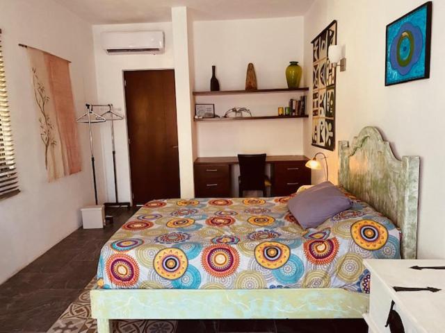 a bedroom with a bed and a desk in it at Acogedora suite con bonito jardin in Cozumel