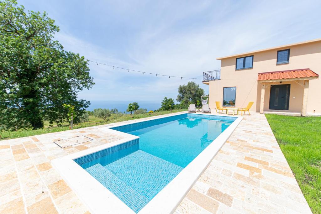 a swimming pool in front of a house at Country home Dolac POOL&SAUNA in Bar