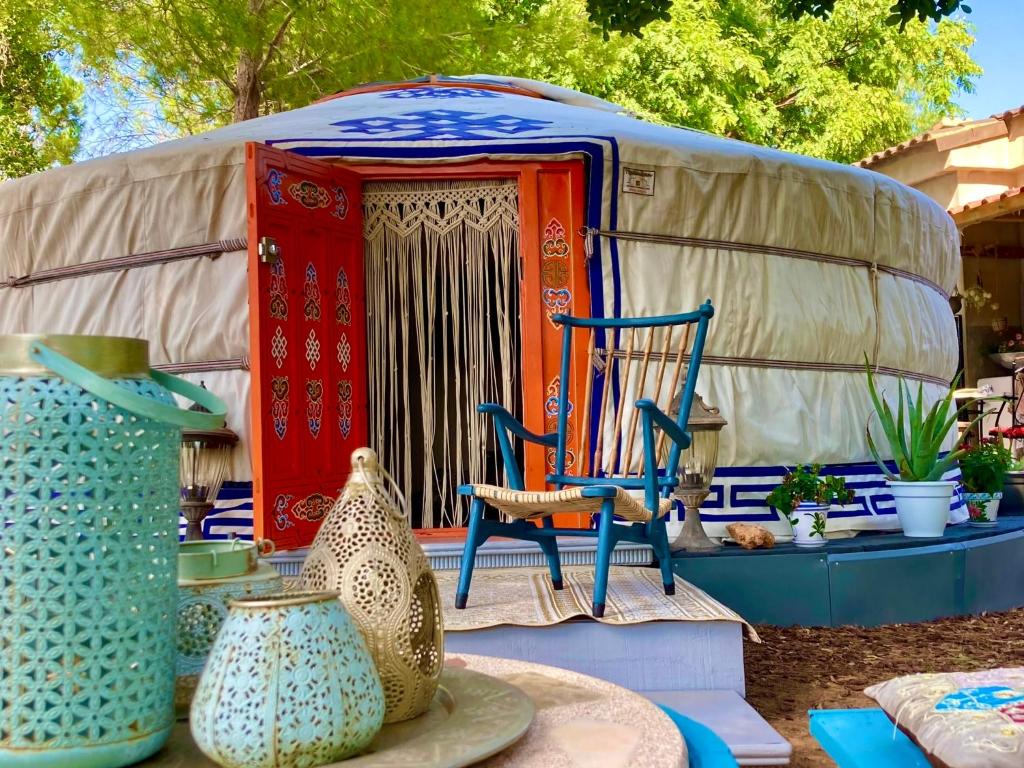una yurta con una silla y jarrones delante en Yurta Arco Iris en Riba-Roja De Turia