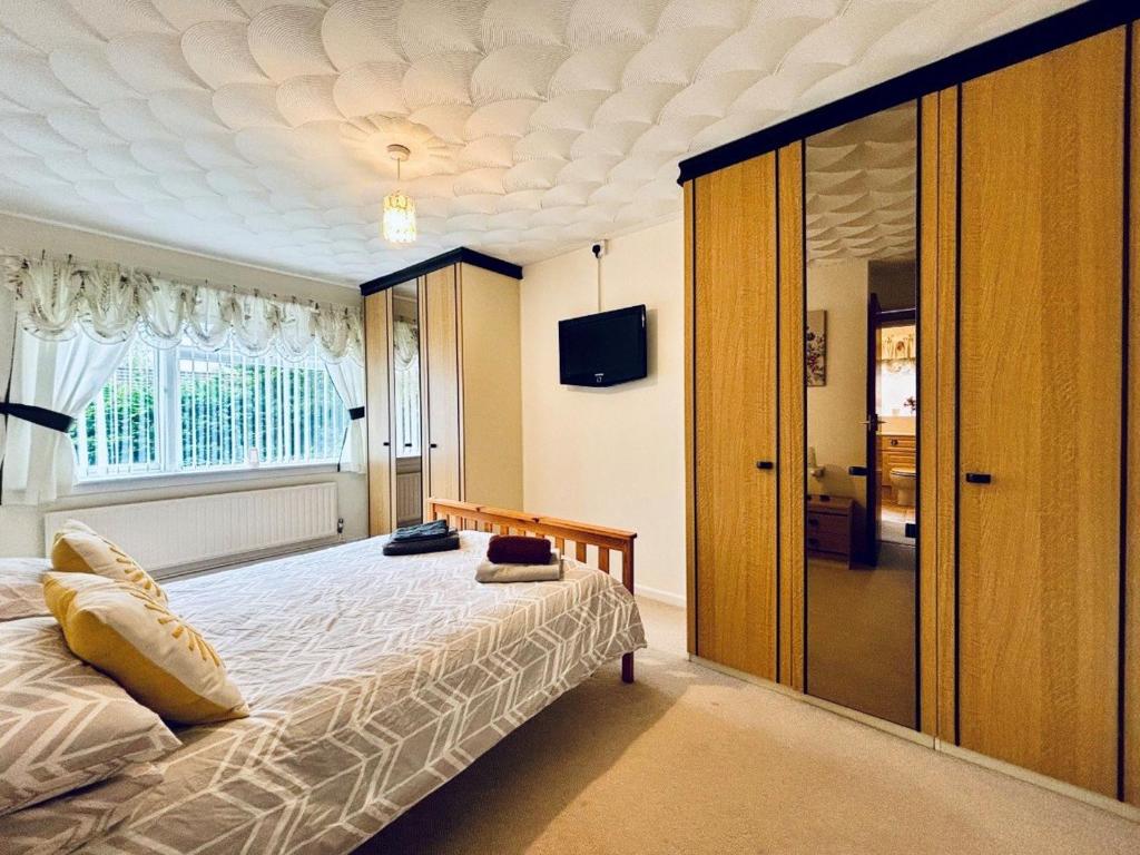 Un dormitorio con una cama grande y una ventana en EEJs Cozy 2-Bedroom Apartment in Nailsea en Nailsea
