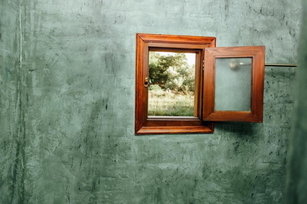 a wooden window on a wall with a green wall at Rose Hedge: mountain rustic cottage in Kamariótis