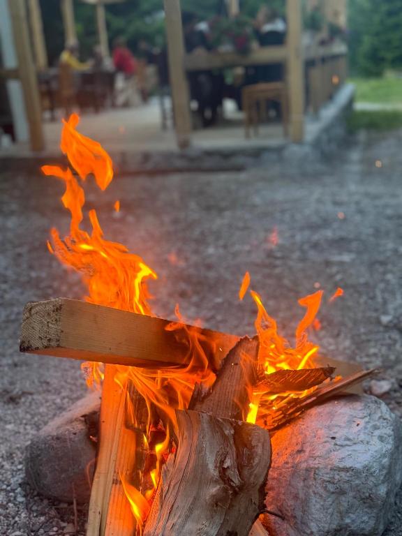 a fire pit with a wooden stick on it at Guest house Hyrmet Demushi in Valbonë