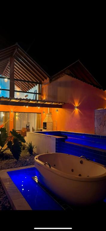a bath tub sitting in front of a house at night at Refugio da praia in Paraty