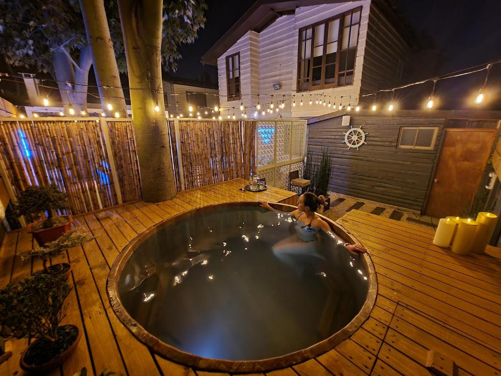 a woman laying in a tub in a backyard at night at Reñaca House Bed & Breakfast in Viña del Mar