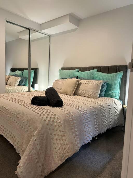 a bedroom with a large white bed with a mirror at 112 at Plush Midnight in Canberra