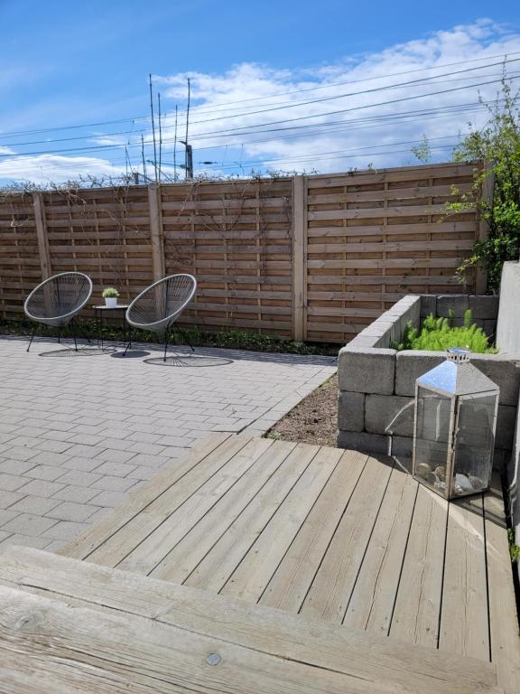 une terrasse avec 2 chaises, une table et une clôture dans l'établissement Riverside apartment in Skien, à Skien